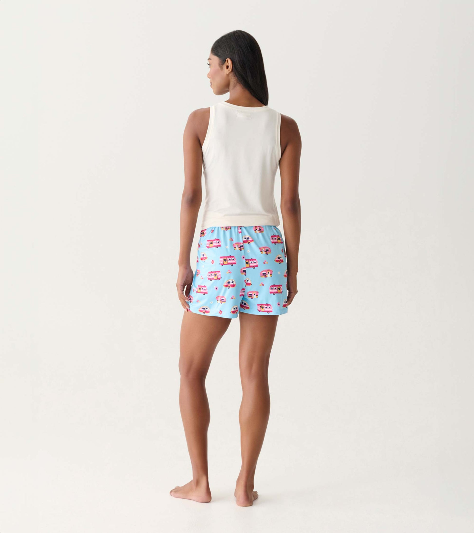 Back view of light blue pajama shorts with colorful camper print and elastic waistband on a model