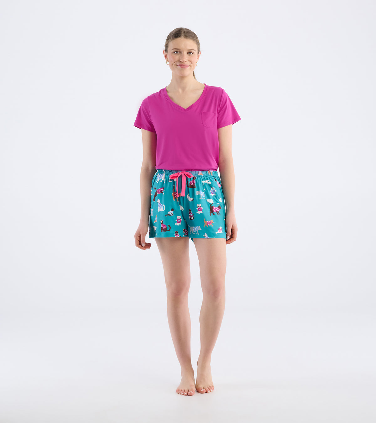 Model wearing teal cat-print pajama shorts with a pink drawstring, front view