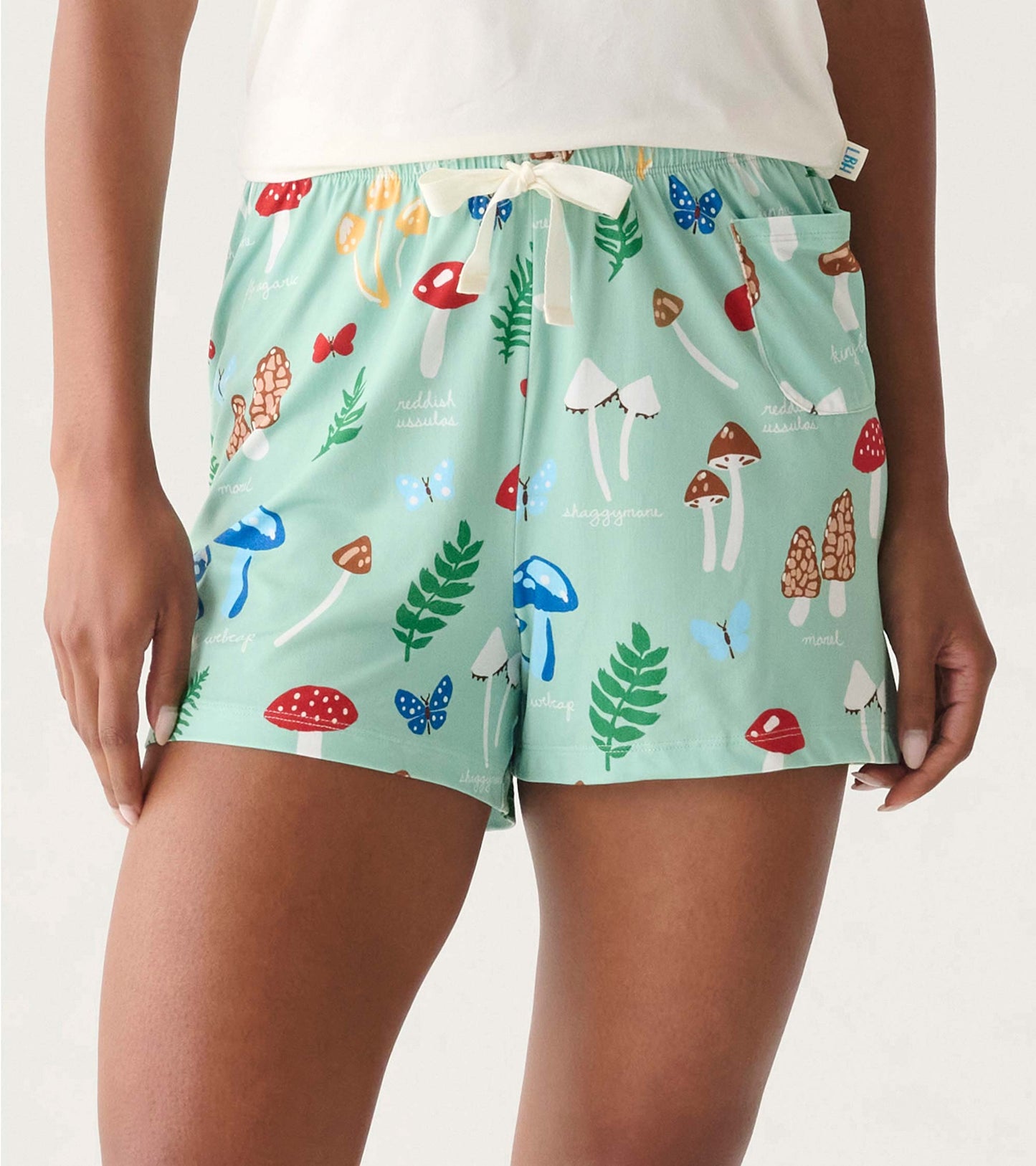Mint green pajama shorts with mushroom, butterfly, and leaf print, elastic waist, and drawstring tie