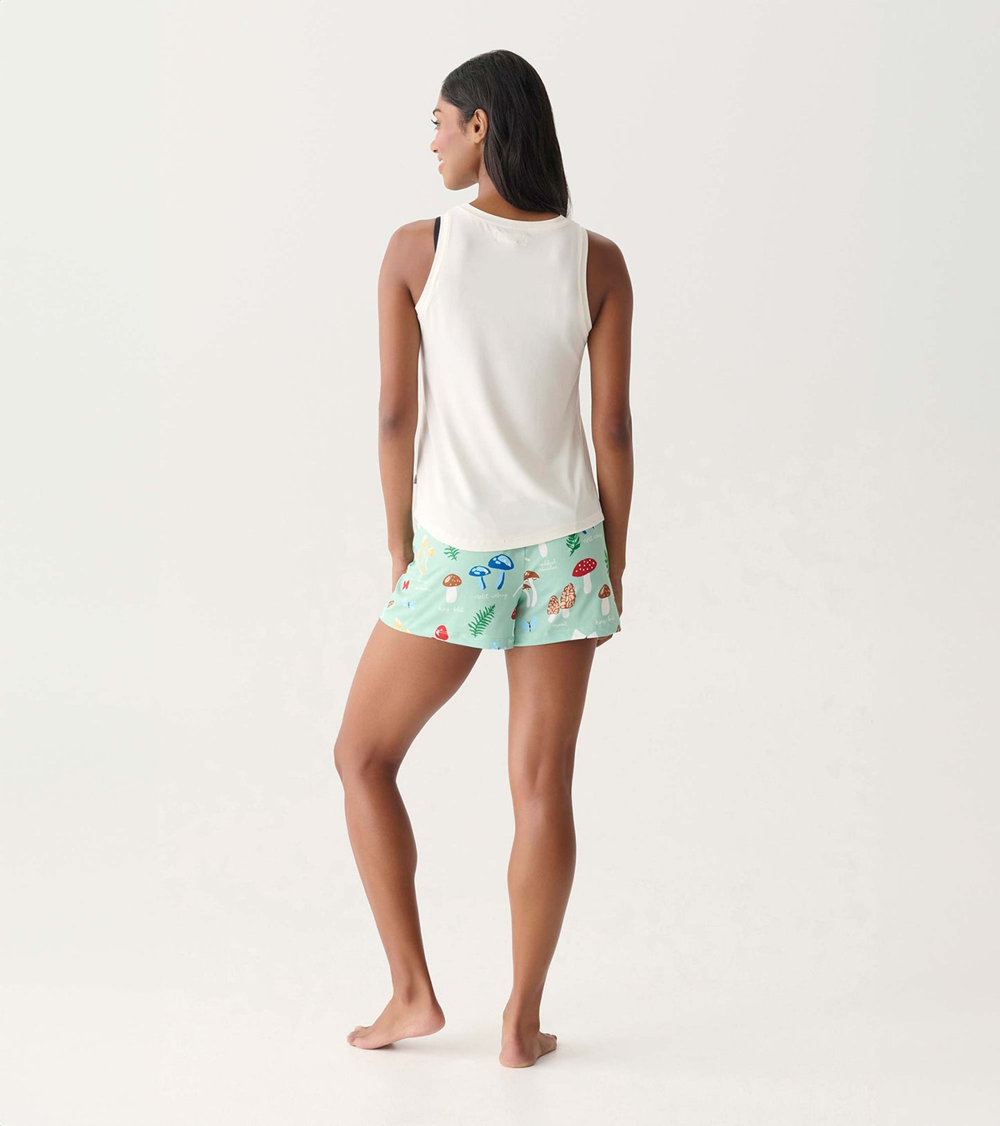 Mint green pajama shorts with colorful mushroom print, shown on a model from the back.