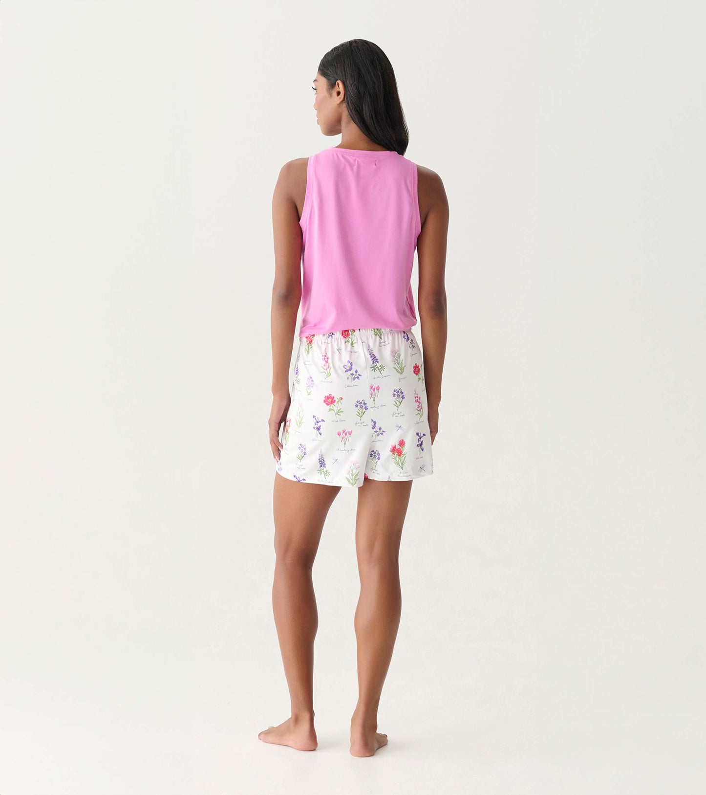 Back view of pink sleeveless top with white floral pajama shorts on model