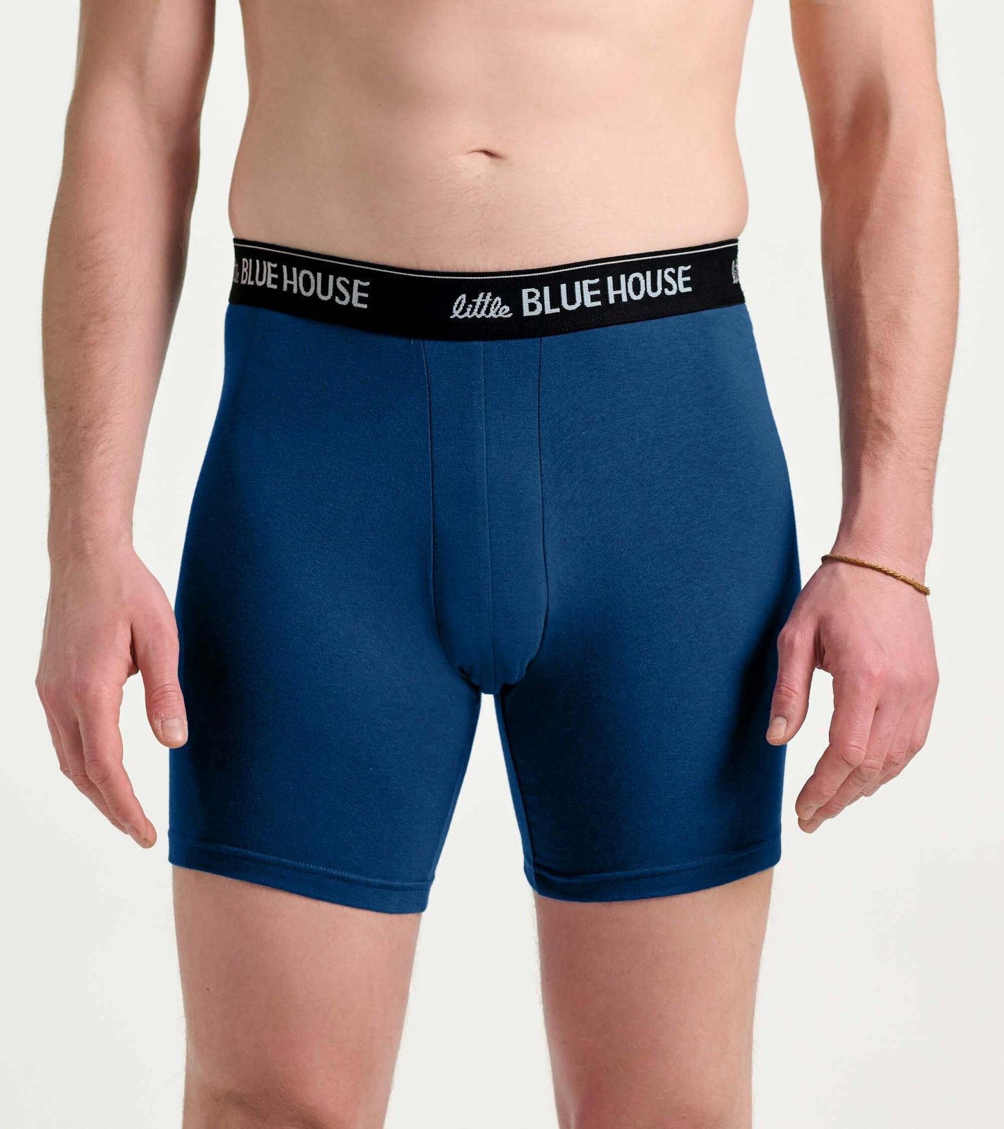 Men's blue boxer briefs with black logo waistband, front view on model