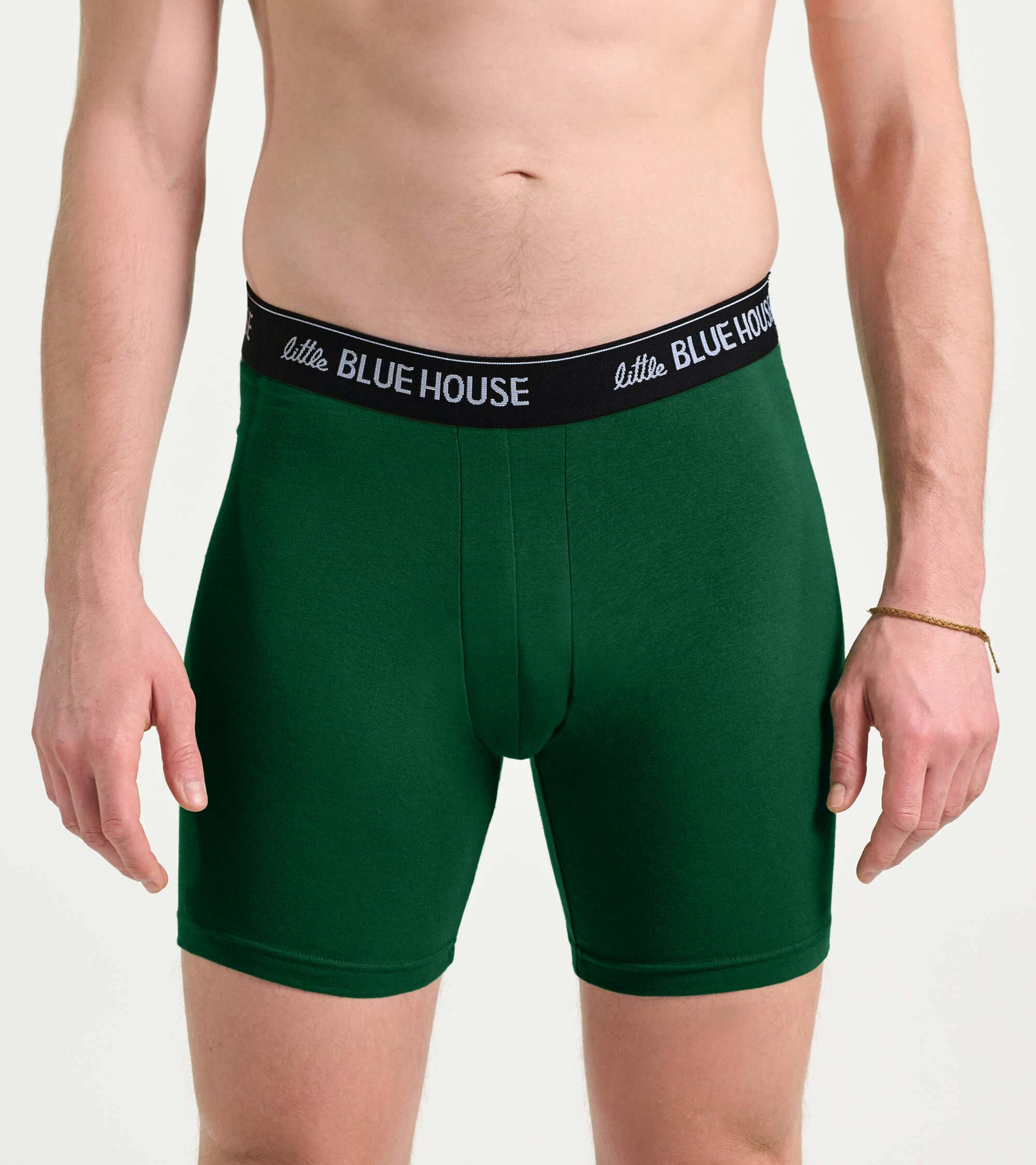 Front view of green boxer briefs with a black logo waistband on a male model