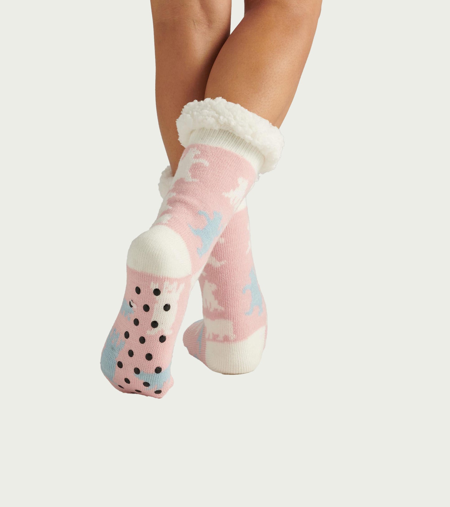 Pink sherpa-lined cabin socks with polar bear pattern and black grippy dots, shown on feet