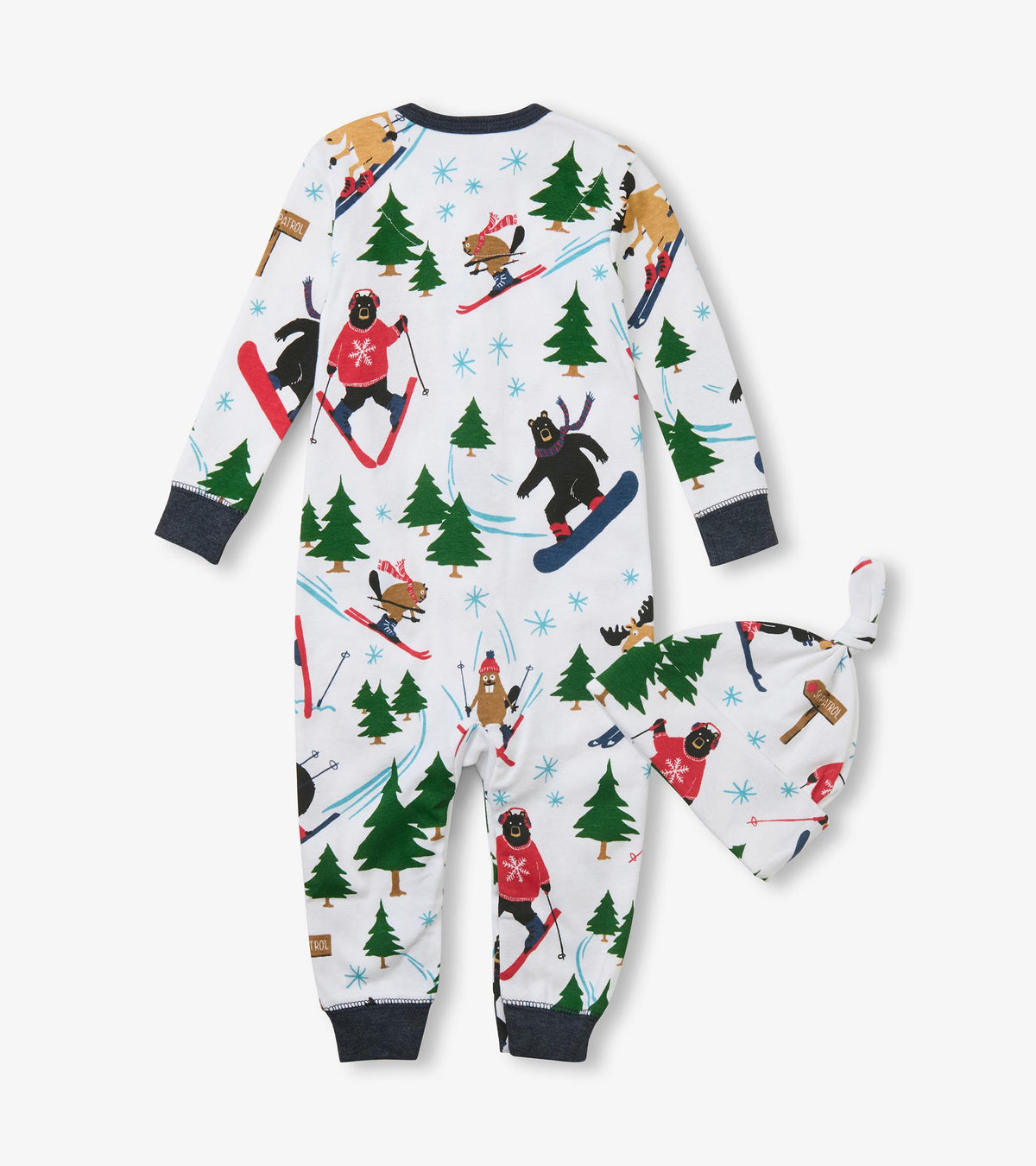 Back of baby sleeper and side of knot hat with skiing animal and evergreen print on white