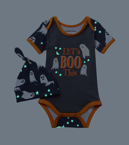 Baby ghost-print bodysuit and matching knot hat shown in the dark with glowing stars and moon details
