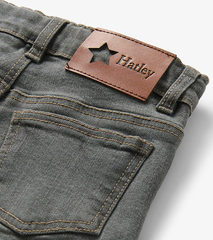 Close-up of the back waistband on charcoal grey jeans with brown Hatley logo patch and rear pocket