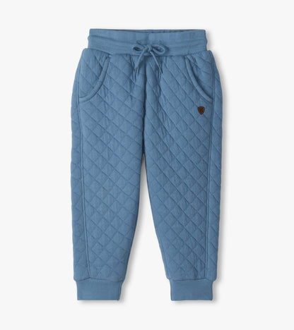 Front view of faded blue quilted joggers with drawstring waist, curved pockets, and ribbed cuffs
