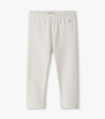 Front view of cream toddler leggings with allover gold glitter speckles and a small silver heart at the waist