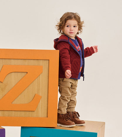 Toddler wearing a madder brown quilted hoodie with blue zipper, shown open in a side-front view