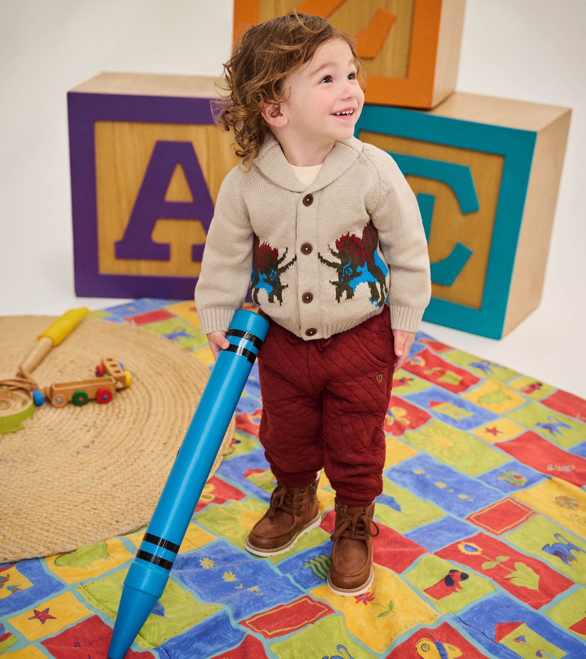 Toddler wearing madder brown quilted joggers with a knit cardigan and brown lace-up boots