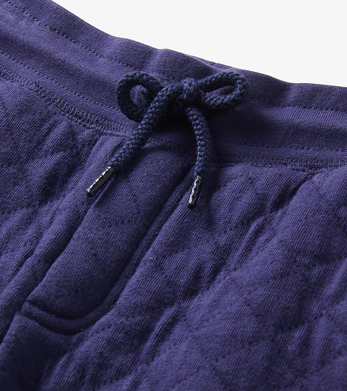 Close-up of patriot blue joggers showing the elastic waistband, navy drawstring, and quilted texture