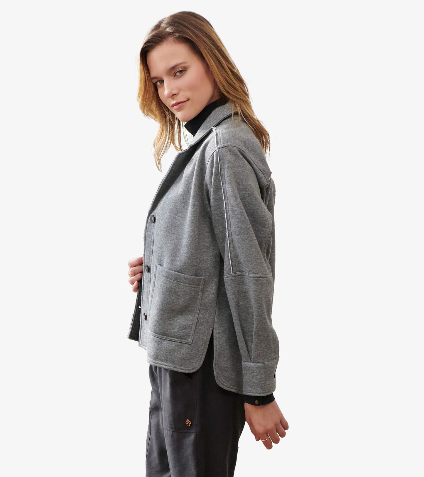 Side view of charcoal melange relaxed blazer showing dropped shoulders, patch pocket and button cuff