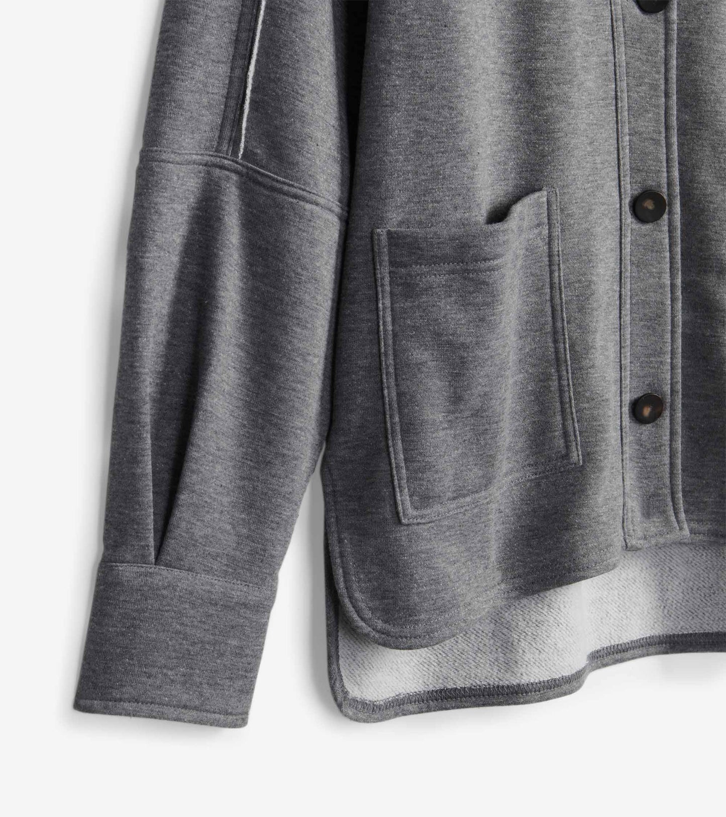 Close-up of charcoal melange blazer with front patch pocket, dark buttons, cuffed sleeve, and curved hem