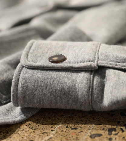 Close-up of charcoal melange blazer sleeve cuff with tab detail and dark button