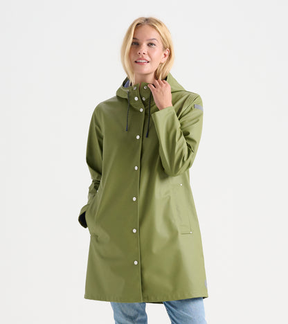 Woman wearing loden green rain jacket with hood, snap front, drawcords, and front patch pockets