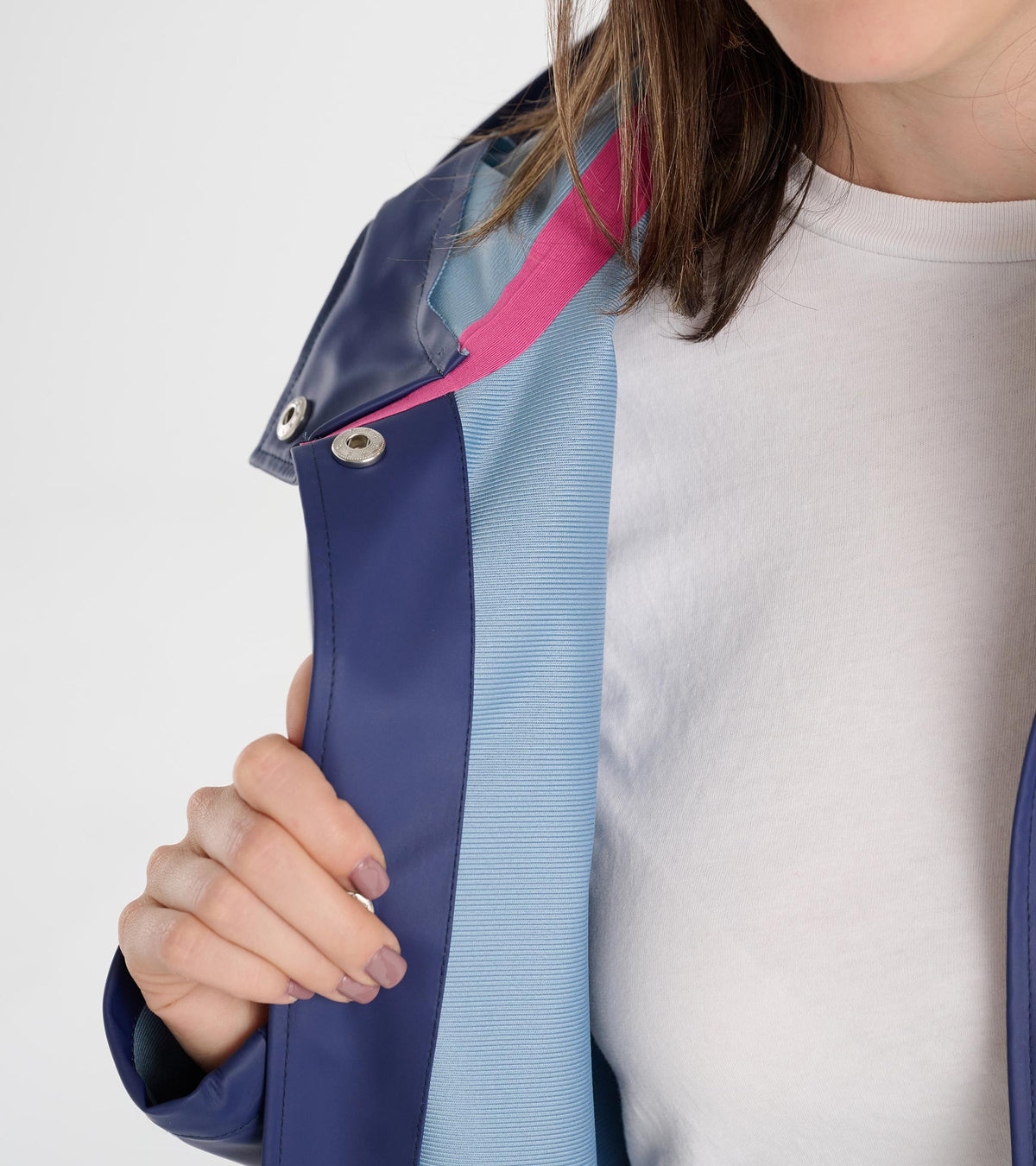 Close-up of patriot blue rain jacket opening with light blue lining, pink seam tape, and silver snaps