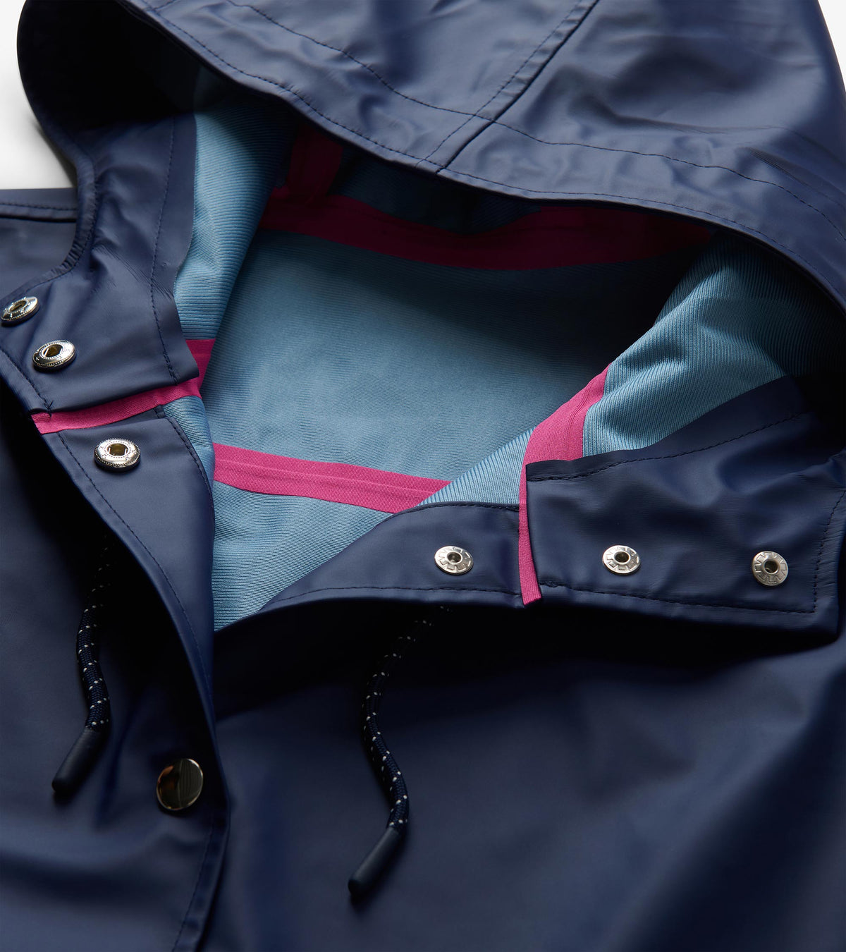 Open hood detail of patriot blue rain jacket with light blue lining, pink seam tape, snaps, and drawcord