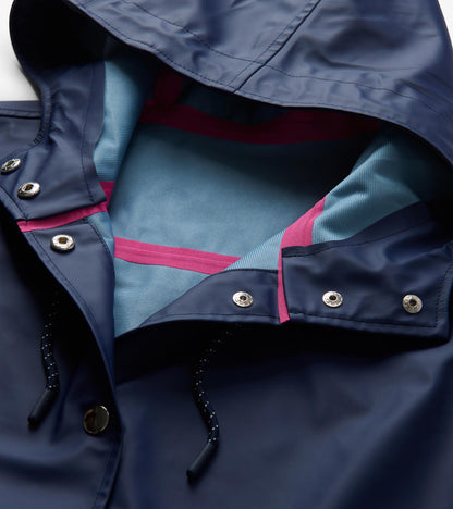 Open hood detail of patriot blue rain jacket with light blue lining, pink seam tape, snaps, and drawcord