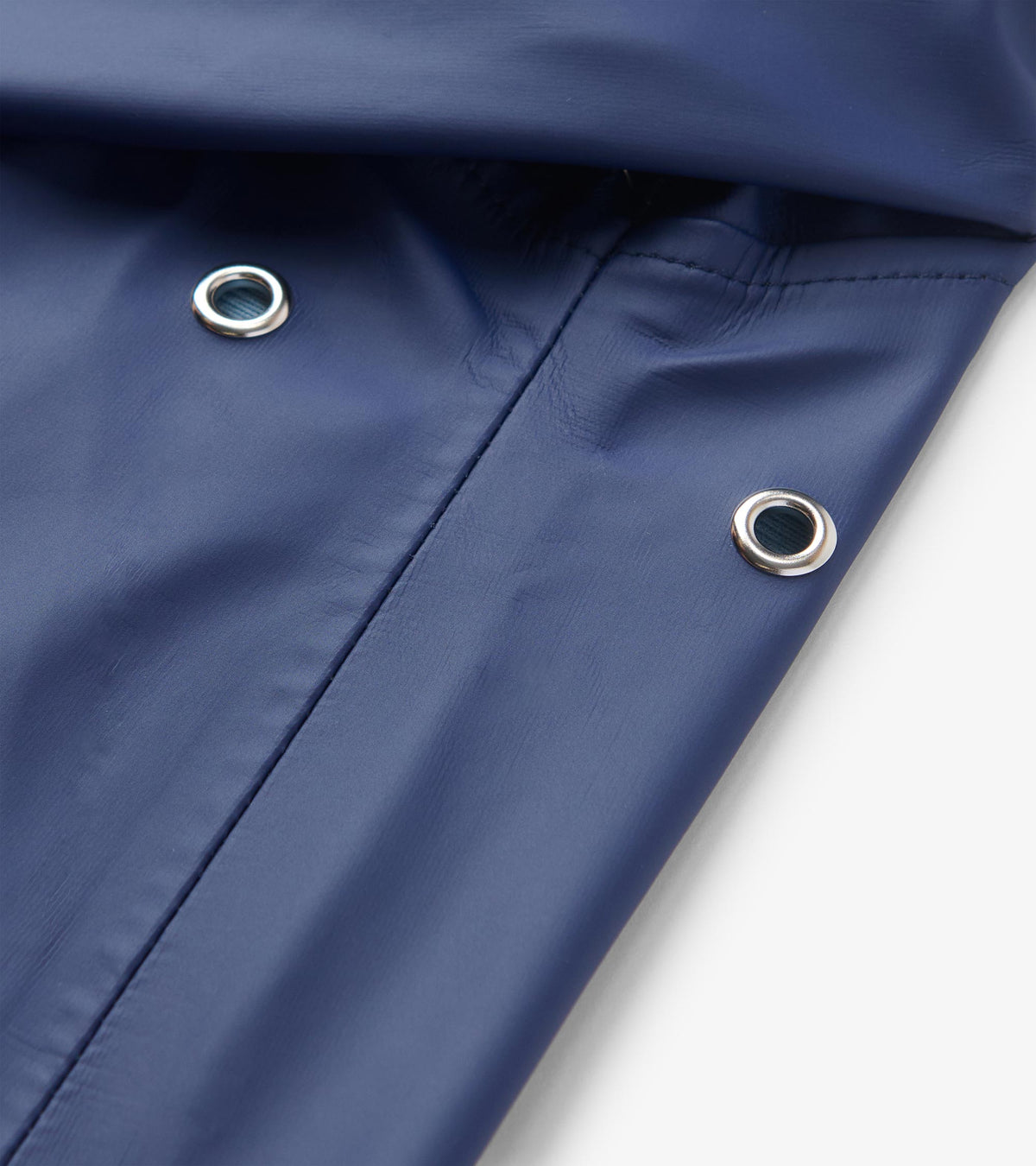 Close-up of patriot blue rain jacket hood with silver metal drawstring grommets and seam detail.