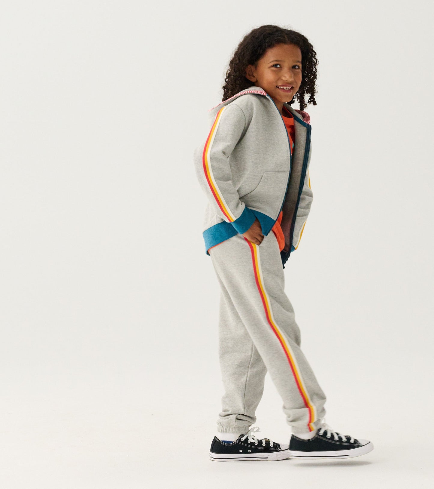 Grey baggy track pants with colorful side stripes, designed for boys, featuring an elastic waistband and cuffs.
