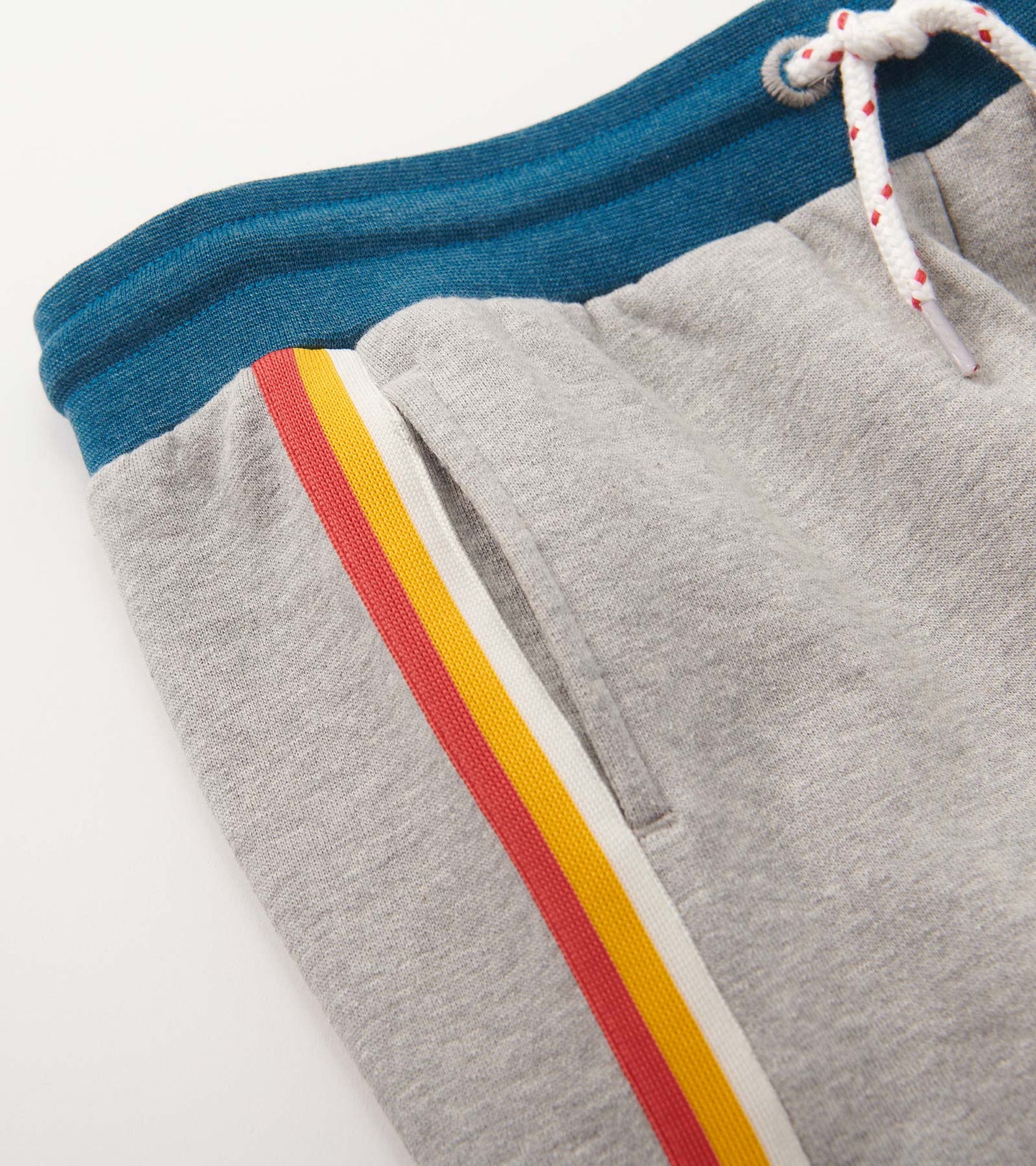 Grey baggy track pants with a blue waistband and colorful side stripes in red, yellow, and white.