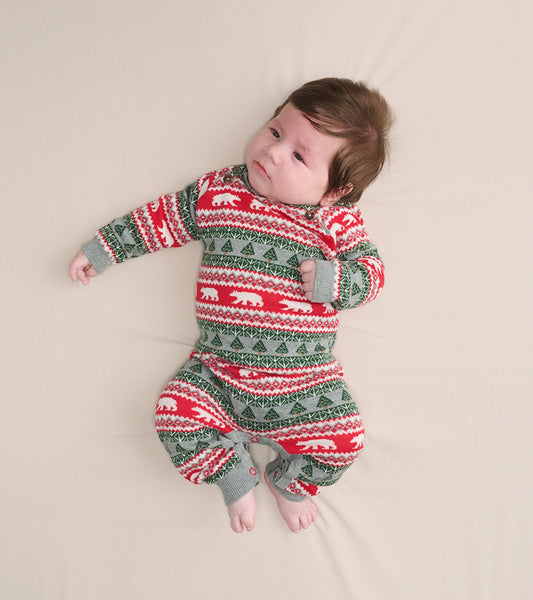 Red and gray Fair Isle sweater romper with polar bear and tree patterns, designed for infants, shown on a light background.