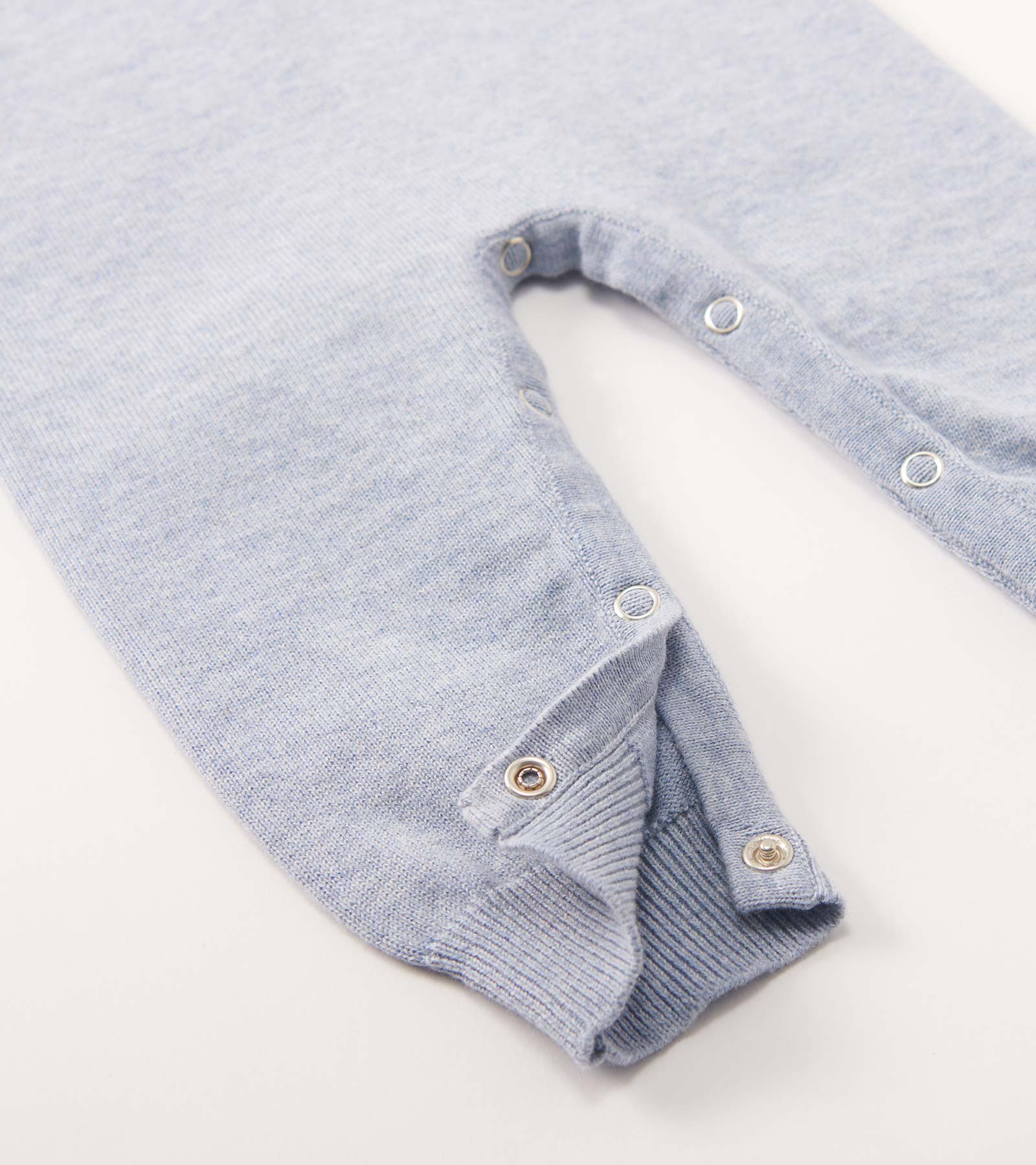 Light blue knit baby romper with snap closures and ribbed cuffs, shown folded on a white background