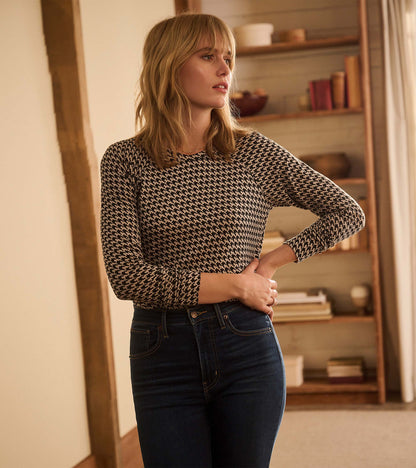 Three-quarter view of Chantel pullover in black and cream houndstooth, tucked into dark jeans