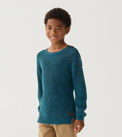 Boy wearing a Moroccan blue knit sweater with three shoulder buttons and tan pants