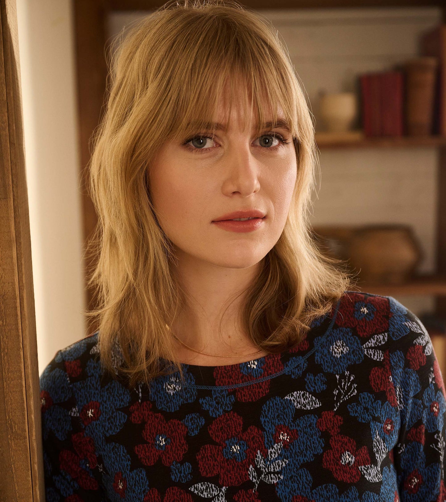 Front view of a black dress with red, blue, and white textured floral print and round neckline