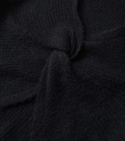 Black cross over sweater made of soft, textured fabric, showcasing a cozy and relaxed design.