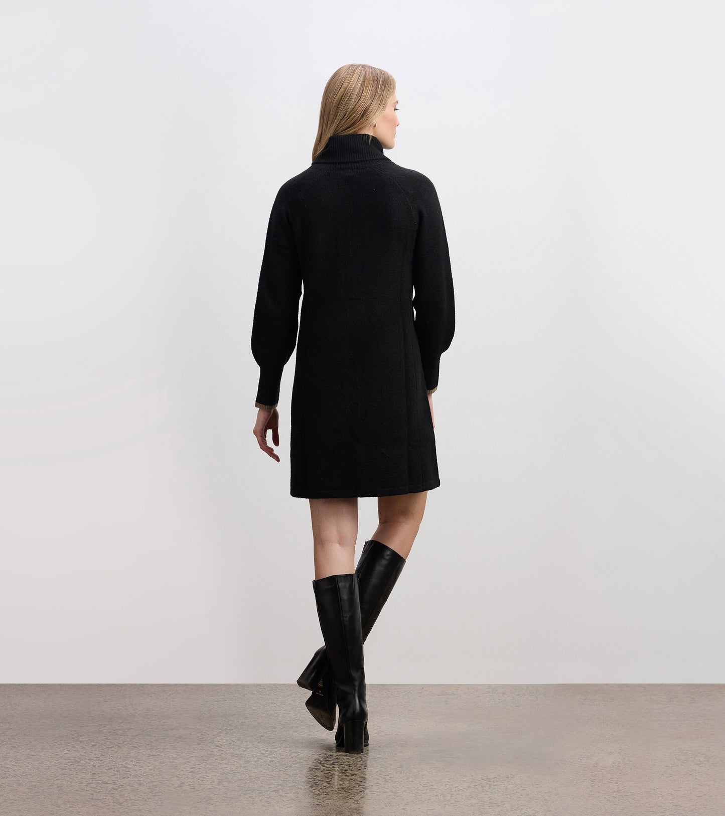 Black sweater dress with a high collar and long sleeves, featuring a relaxed fit and knee-length design.