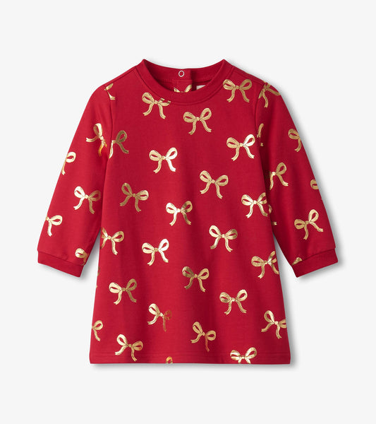 Red dress featuring a pattern of gold ribbon bows, long sleeves, and a round neckline, suitable for baby and toddler girls.