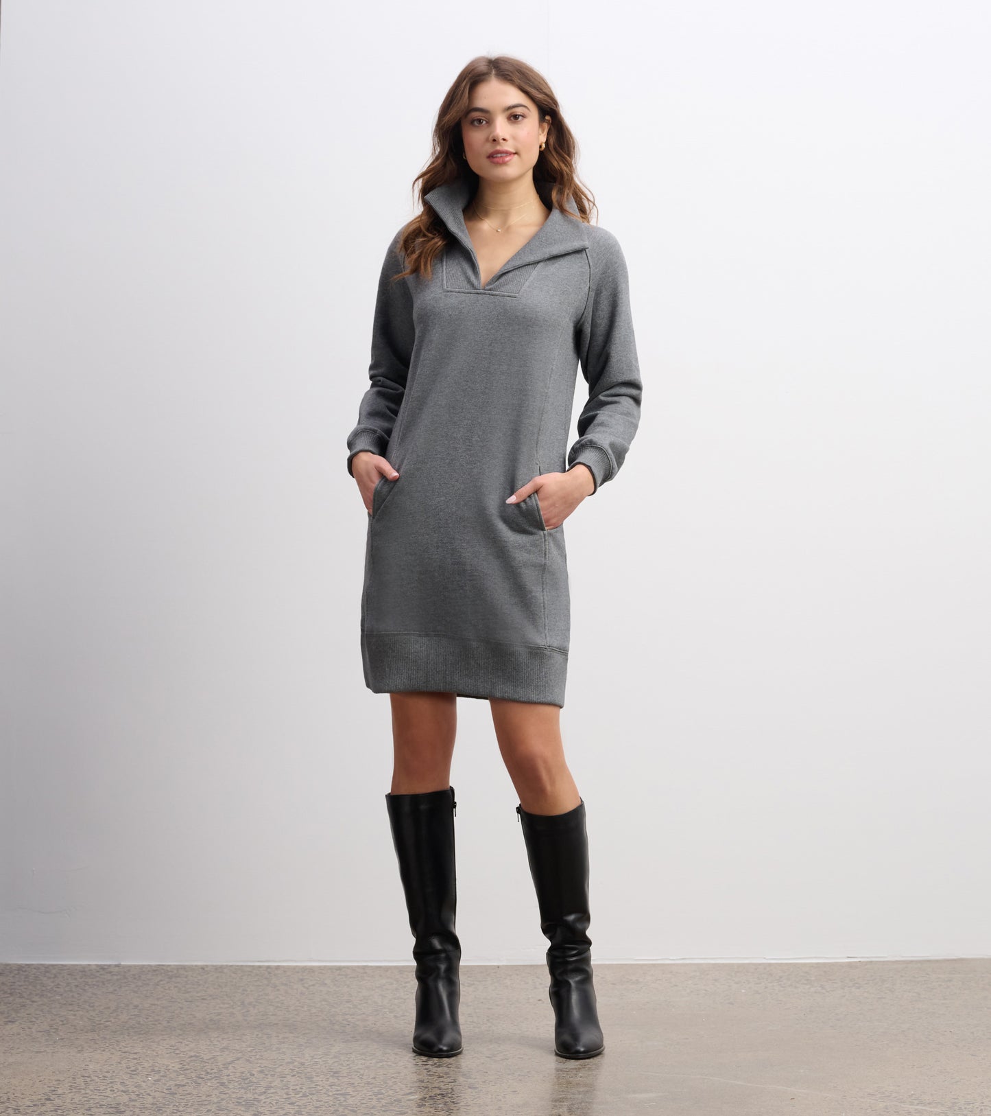 Charcoal melange dress with a notch neck, long sleeves, and side pockets, styled with knee-high black boots.