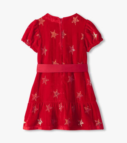 Back view of red dress with puff sleeves, sequin stars, back zipper, and tiered skirt
