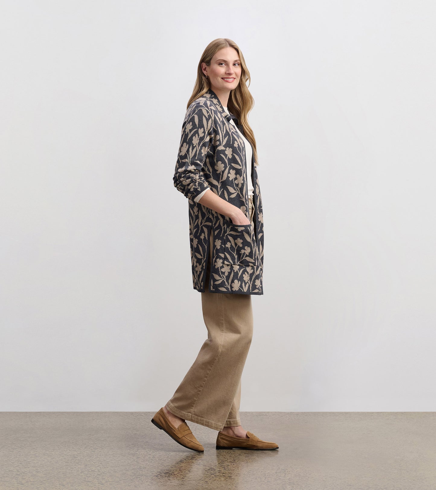 Floral vine patterned sweater blazer in navy with pockets, worn over a white top and beige pants.