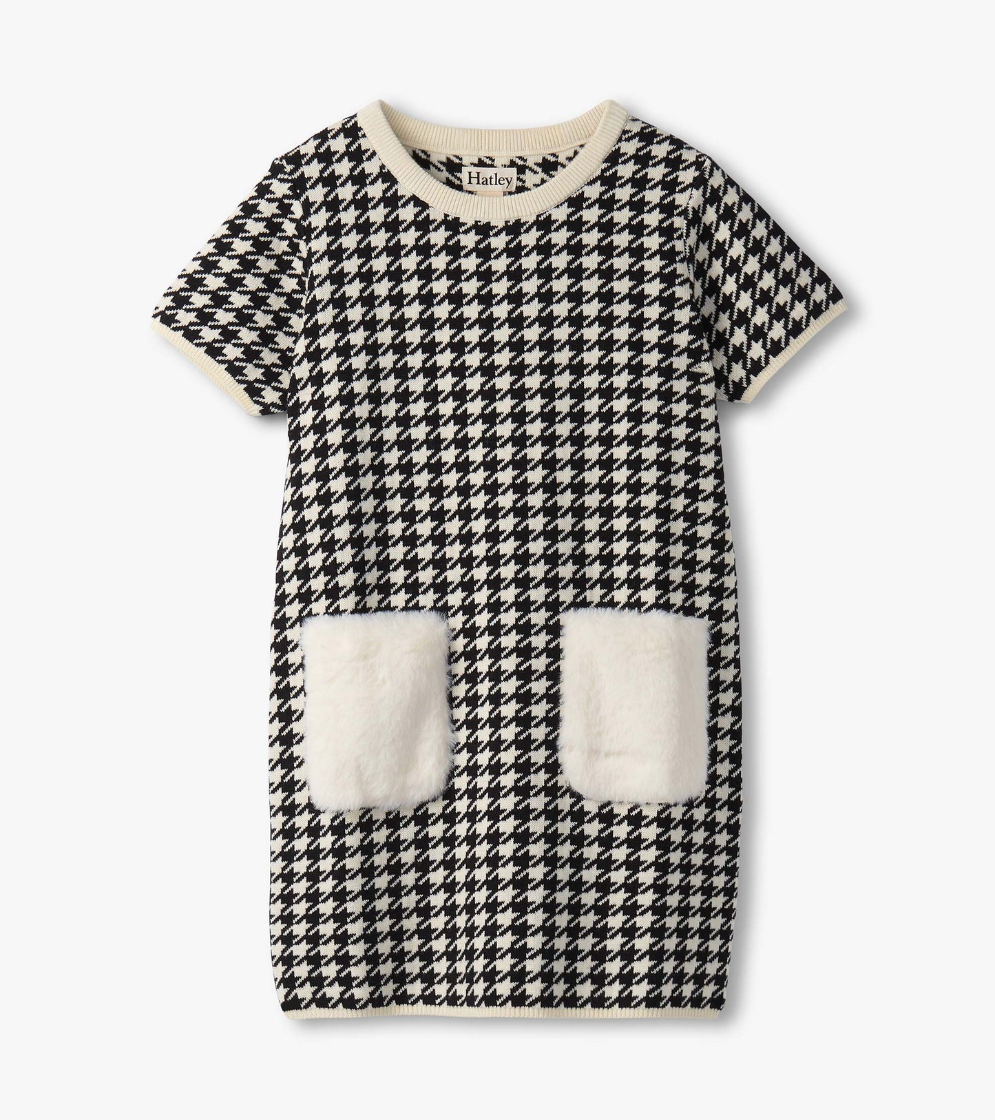 Black and white houndstooth sweater dress featuring faux fur pockets and a ribbed neckline. Short sleeves, knee-length desig…