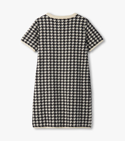 Black and white houndstooth sweater dress with short sleeves and a ribbed neckline, featuring faux fur pockets.