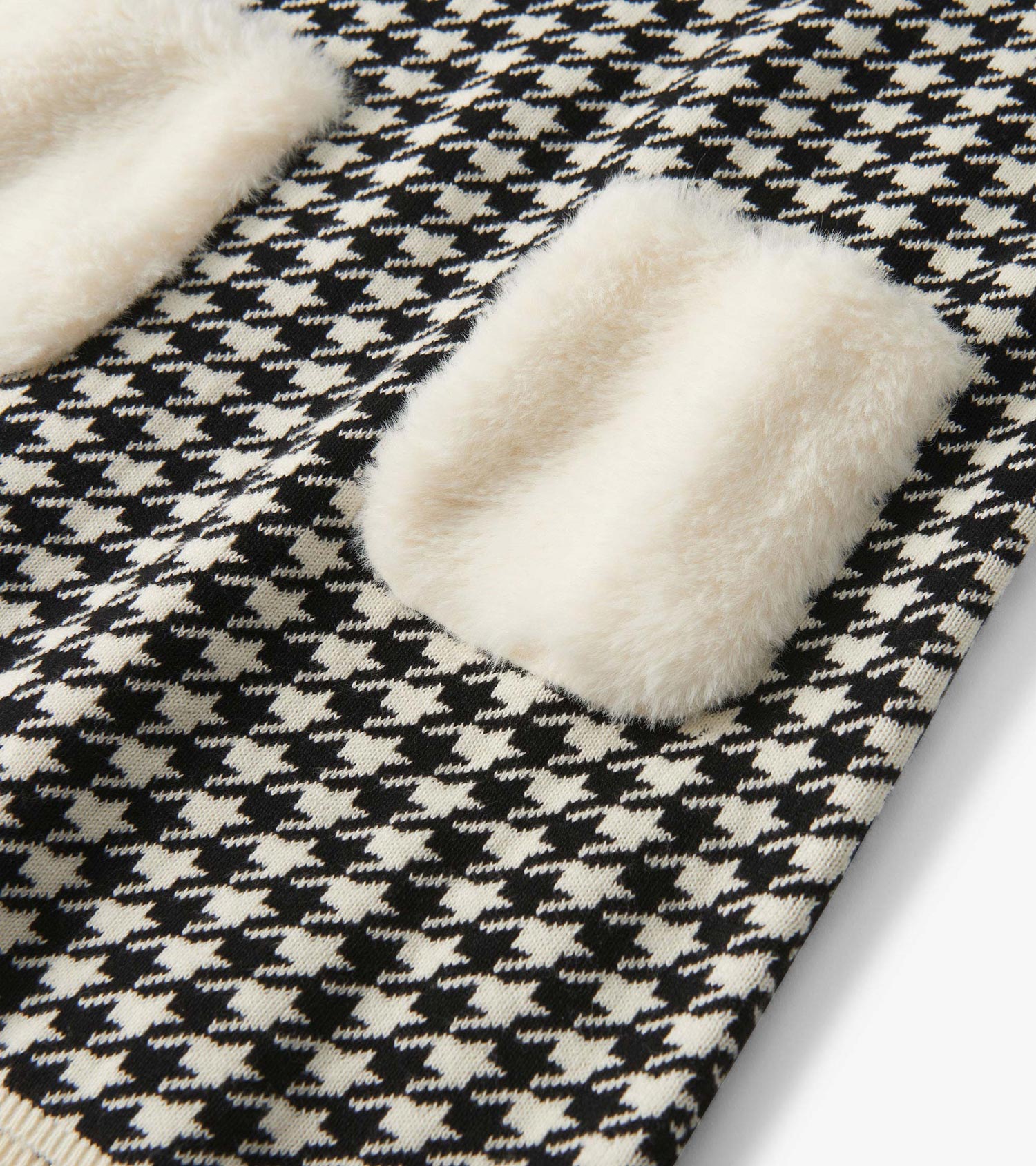 Black and white houndstooth sweater dress featuring soft faux fur pockets.