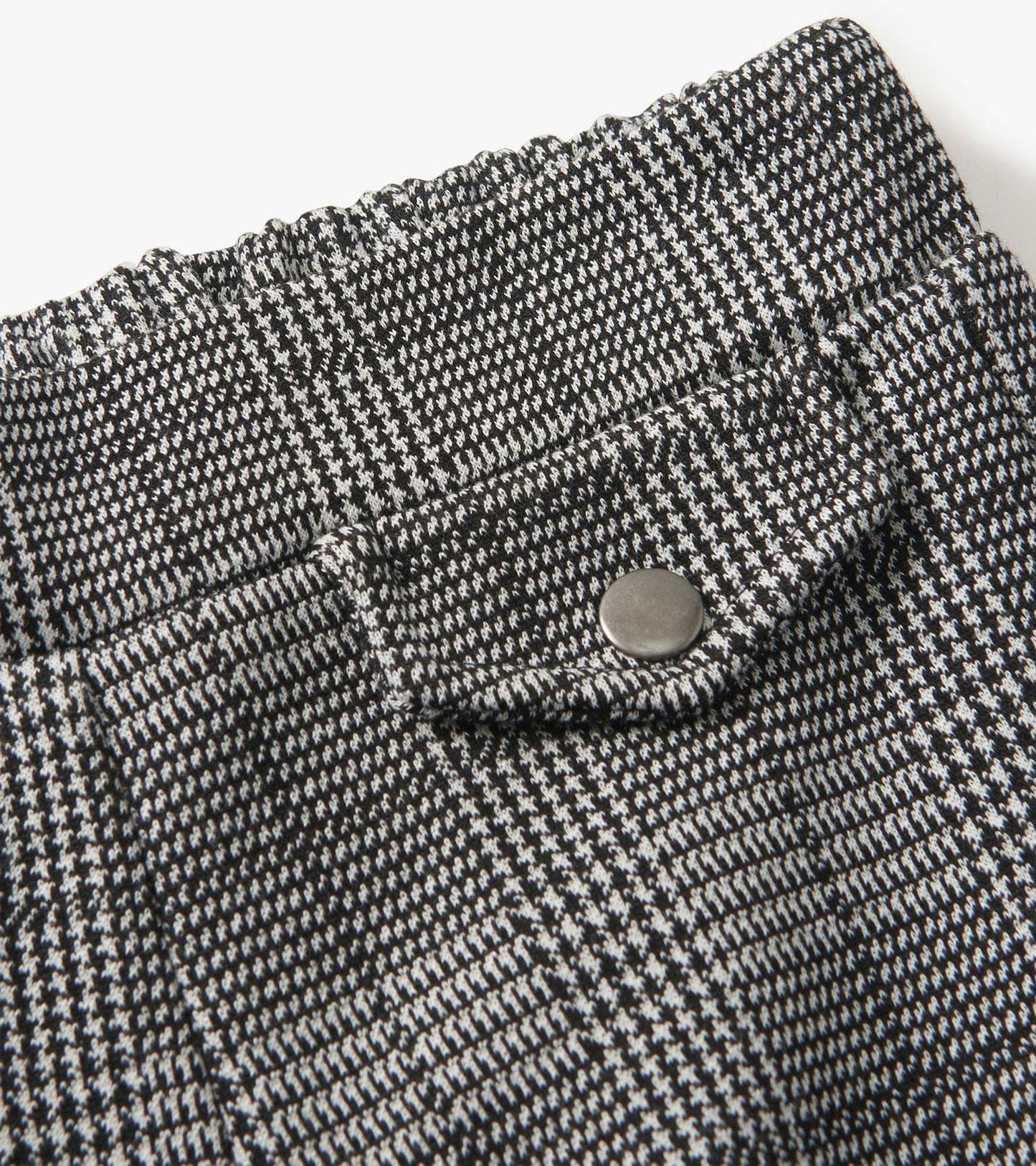 Black and white houndstooth plaid wide leg pants with an elastic waistband and a decorative button detail.
