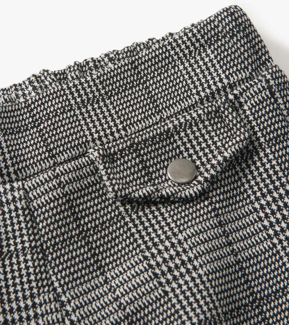 Black and white houndstooth plaid wide leg pants with an elastic waistband and a decorative button detail.
