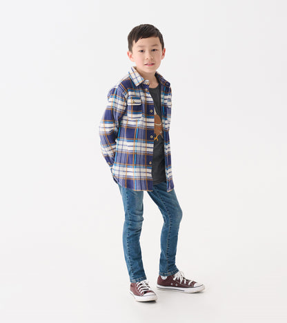 Blue and white plaid fleece button-up shirt with two chest pockets, worn over a gray t-shirt and paired with jeans.