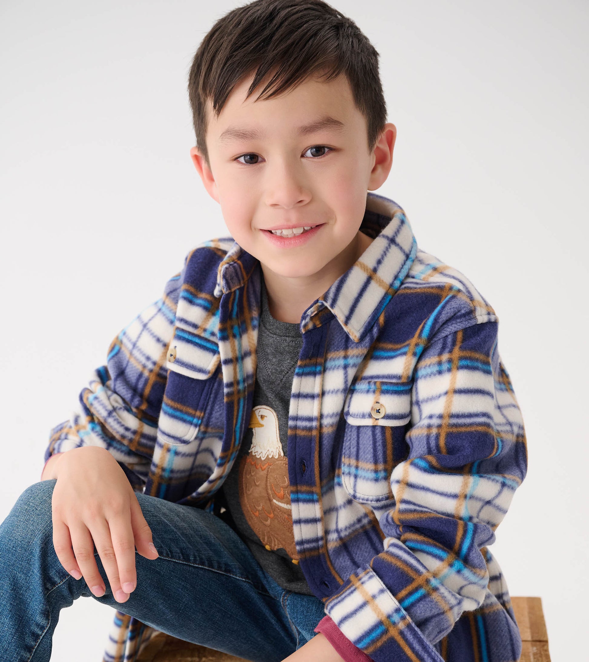Plaid fleece button-up shirt in blue, white, and brown, featuring two chest pockets, worn over a gray shirt.