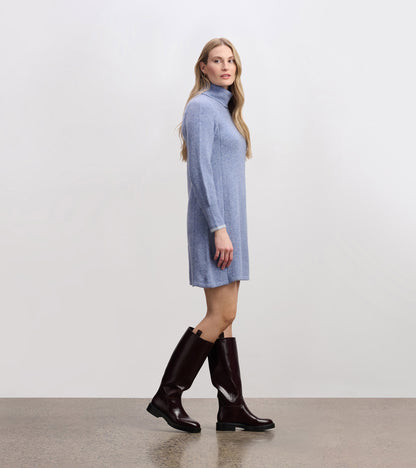 Light denim sweater dress with a high collar, long sleeves, and a relaxed fit, paired with knee-high brown boots.