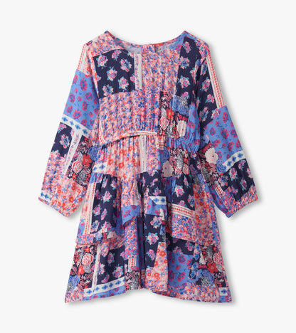 Colorful patchwork floral dress with long sleeves and a flounce hem, featuring shades of blue, pink, and navy.