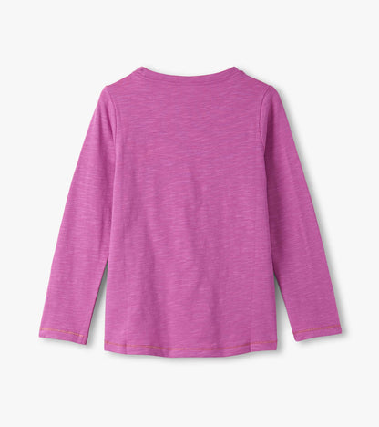 Long sleeve graphic tee in a soft pink hue with a smooth texture, featuring a classic crew neckline.