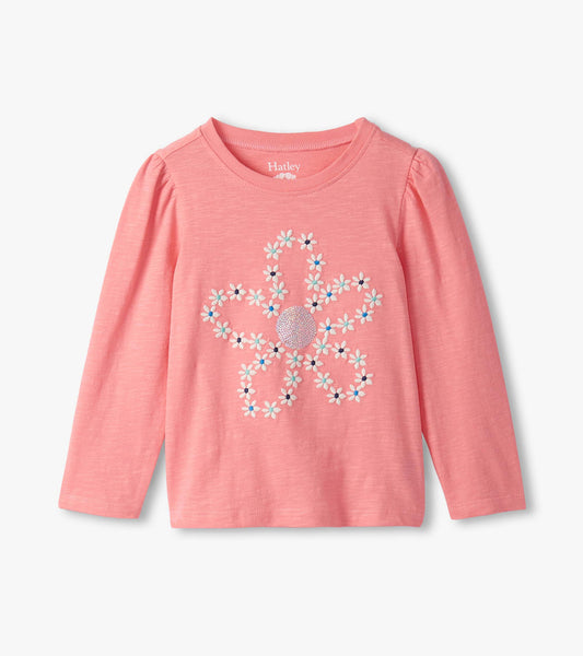 Pink long-sleeve tee featuring embroidered flower design with colorful accents and puff sleeves.