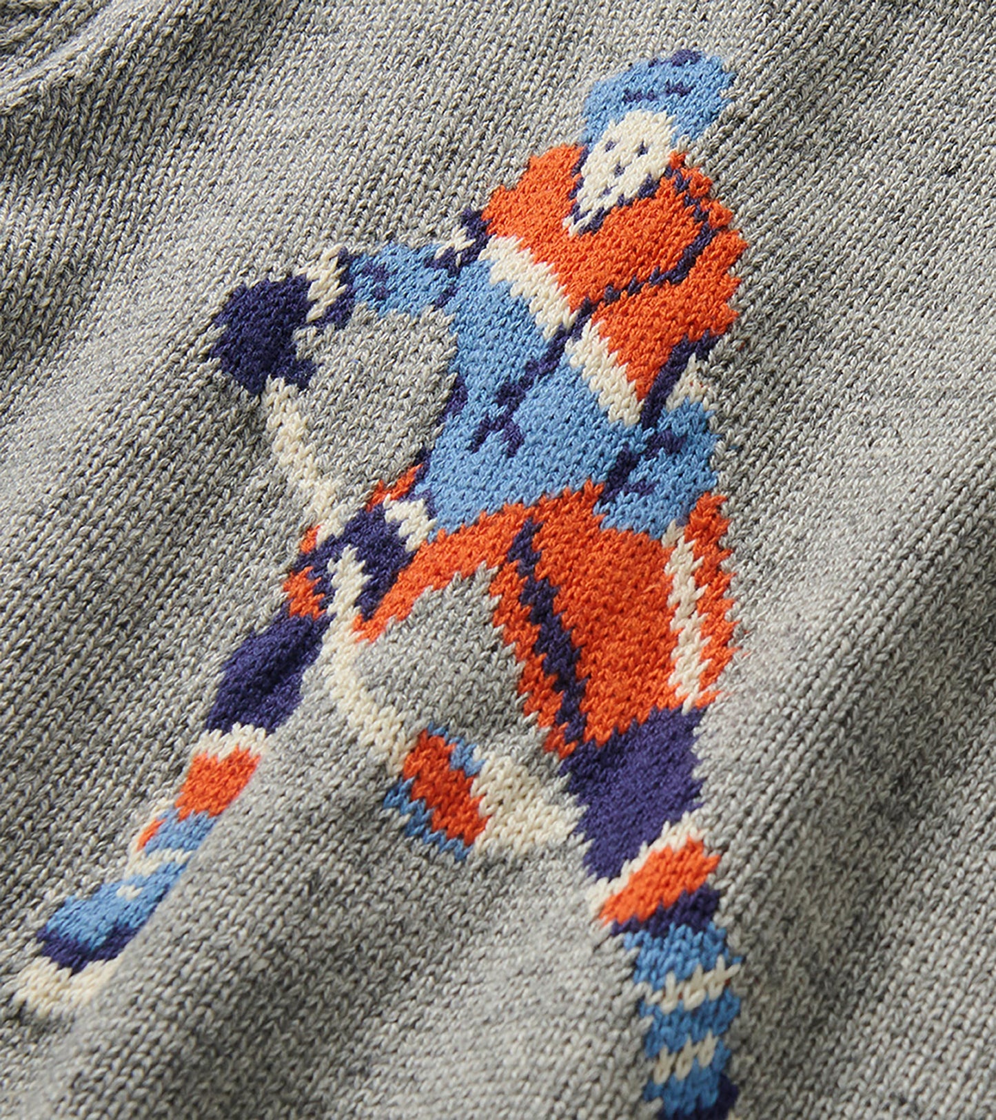 Close-up of the colorful hockey player knit detail on the heather gray sweater