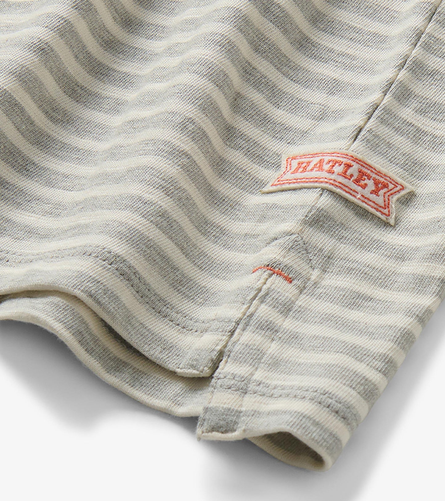 Close-up of the striped rugby shirt hem with side slit and visible Hatley logo tag